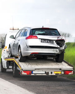 Damaged car on tow truck bed.