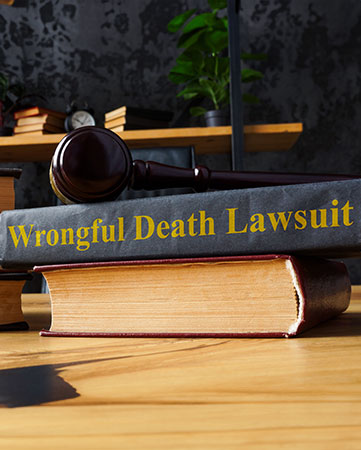 Book on wrongful death lawsuit on top of law books on table.