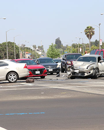 a damaged car in front of other cars on road